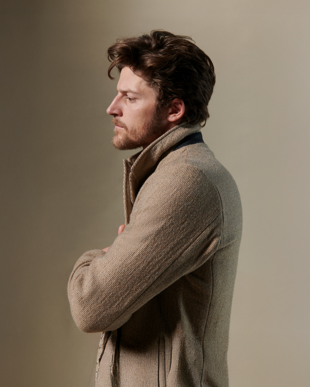 Model wears a tan Billy Reid custom suit against a beige background.