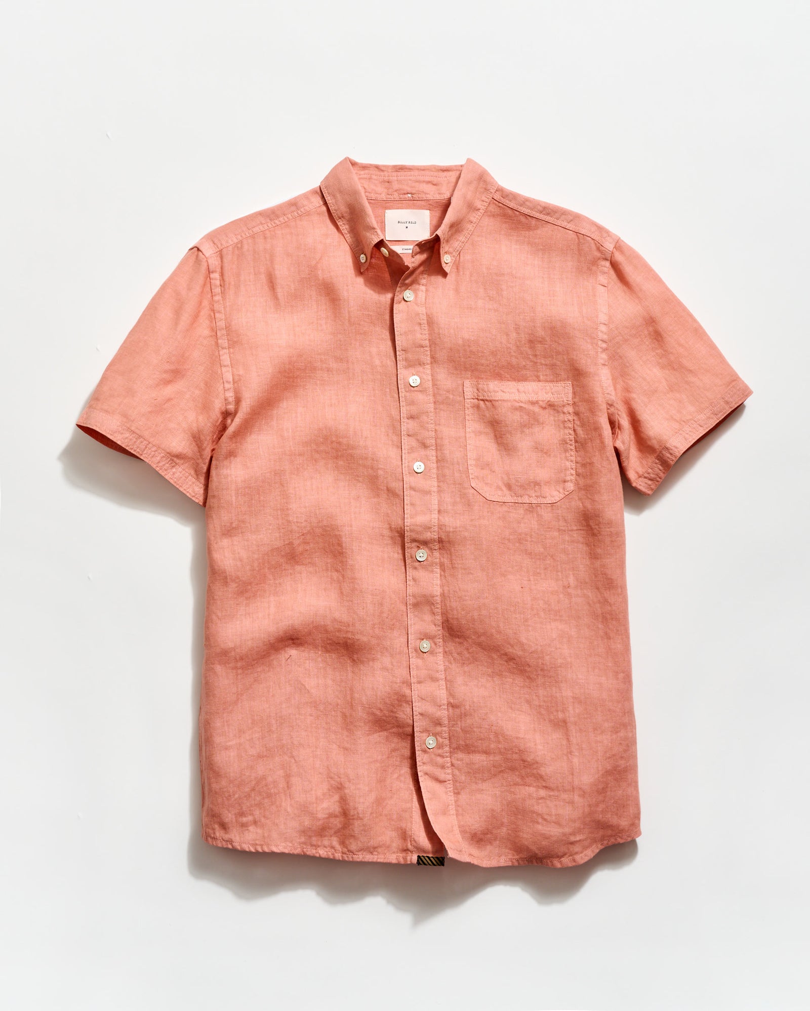 Pink short-sleeve button-up shirt on a light gray background