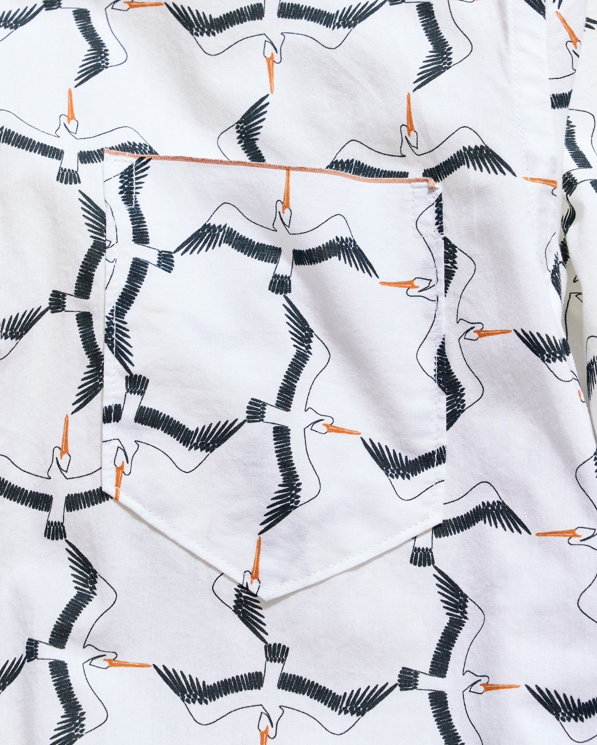 White fabric with black and orange bird pattern