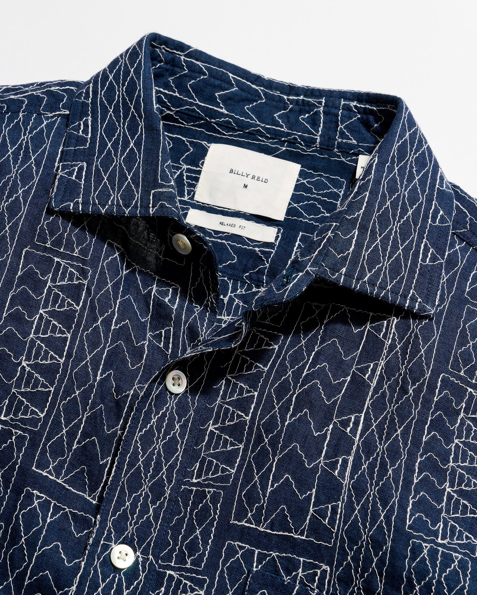 Navy blue shirt with white geometric pattern on a white background