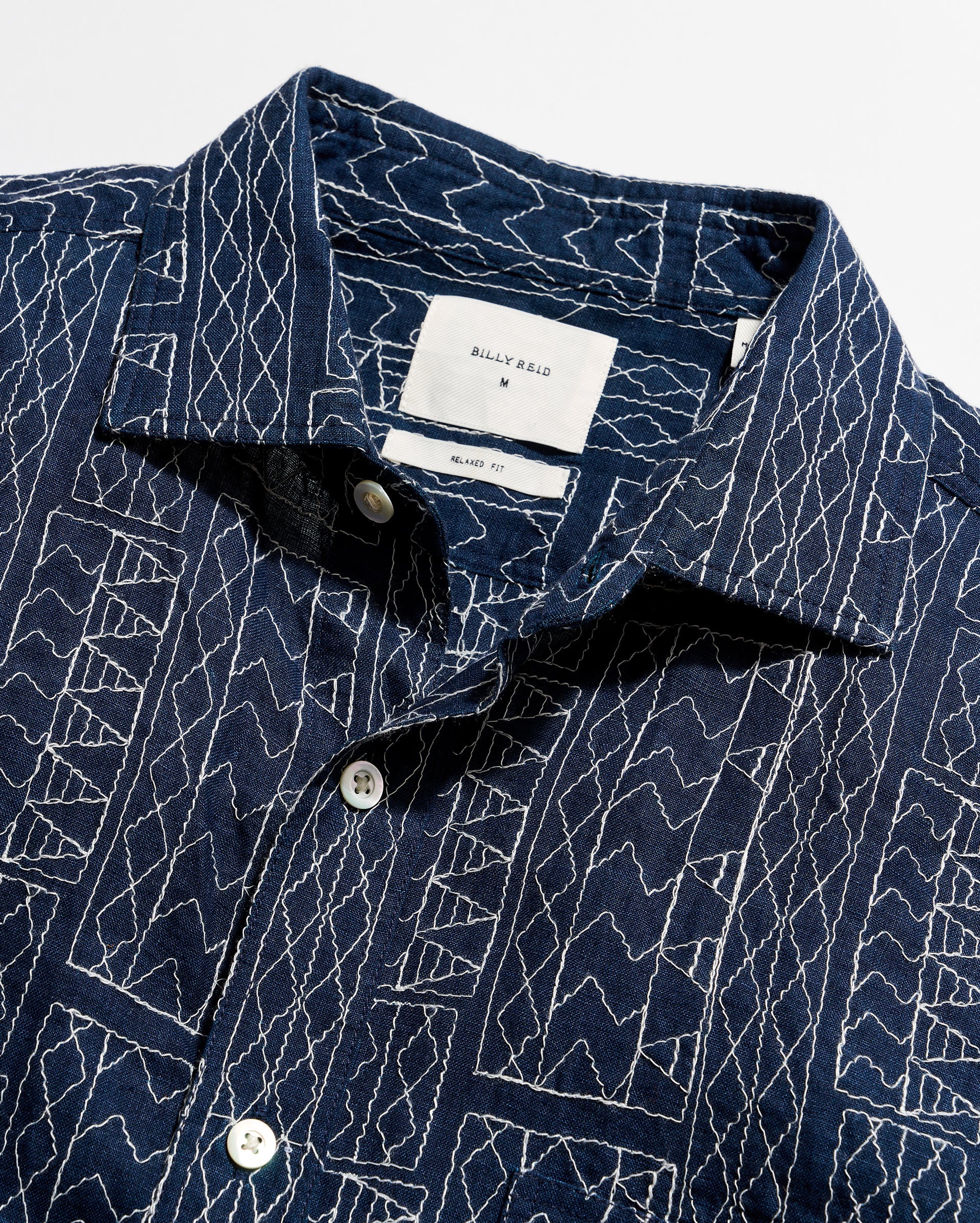 Navy blue shirt with white geometric pattern on a white background