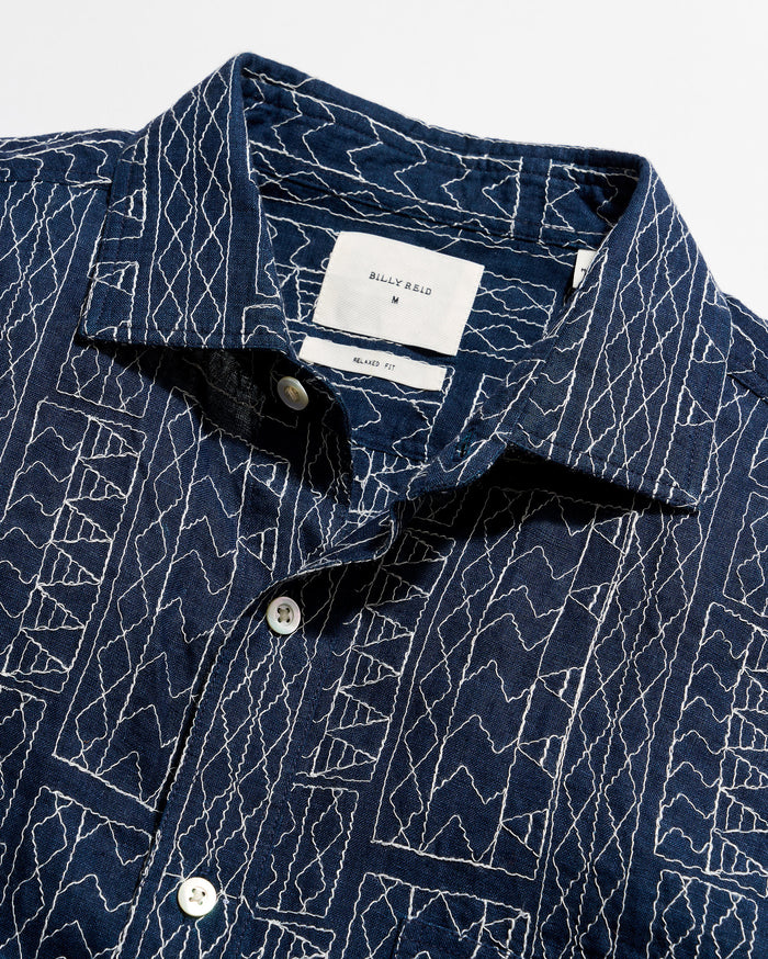 Navy blue shirt with white geometric pattern on a white background
