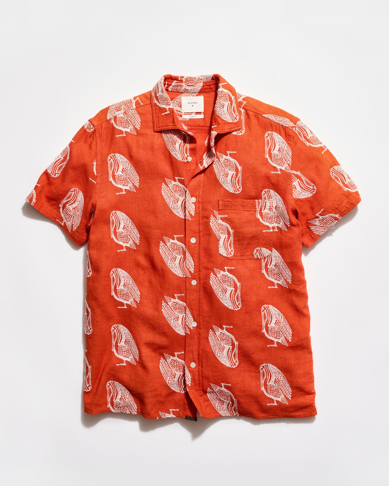 Orange shirt with white bird pattern on a white background