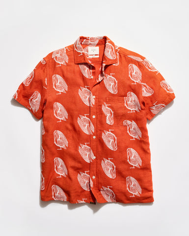 Orange shirt with white bird pattern on a white background