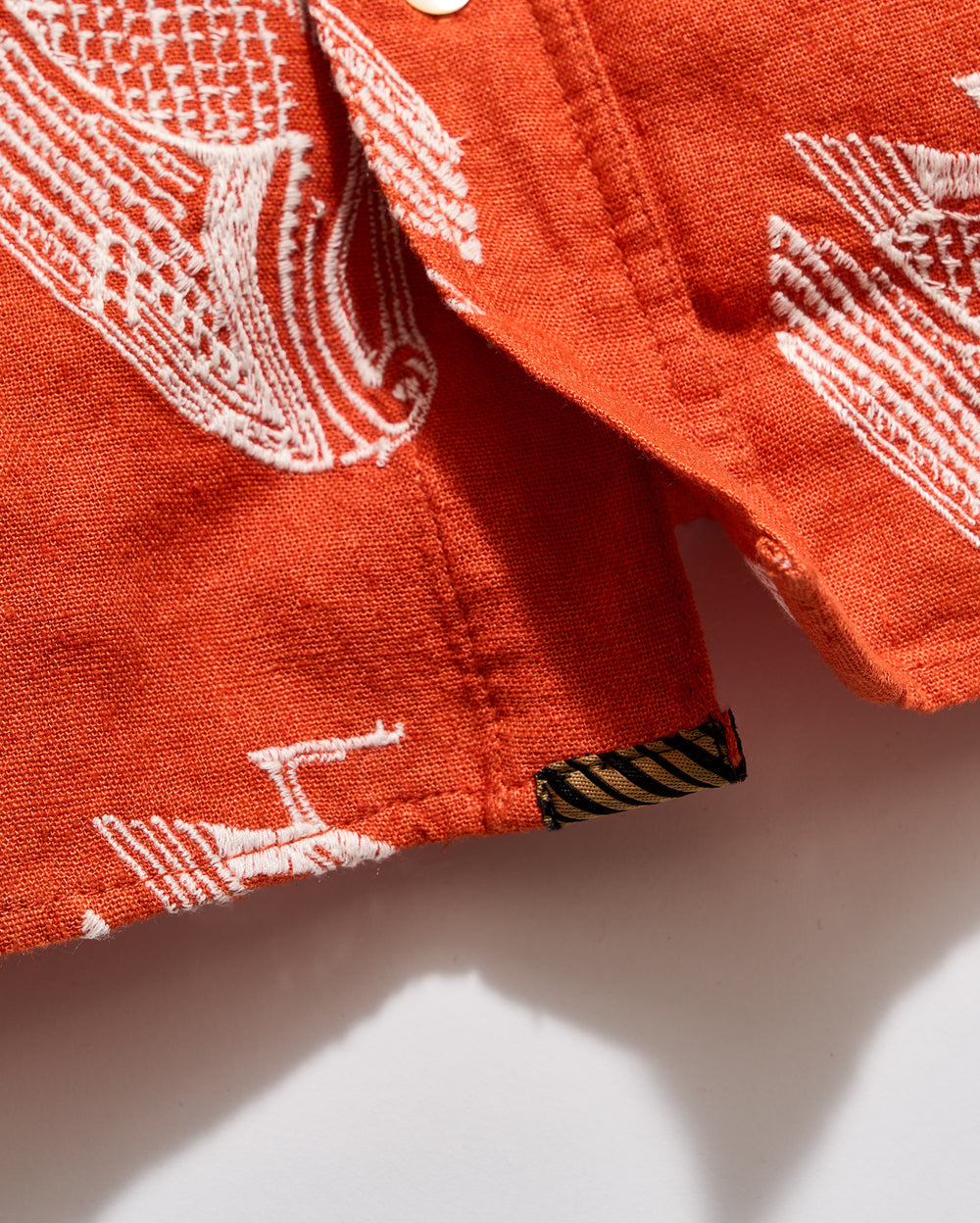 Close-up of a red fabric with white patterns on a light background