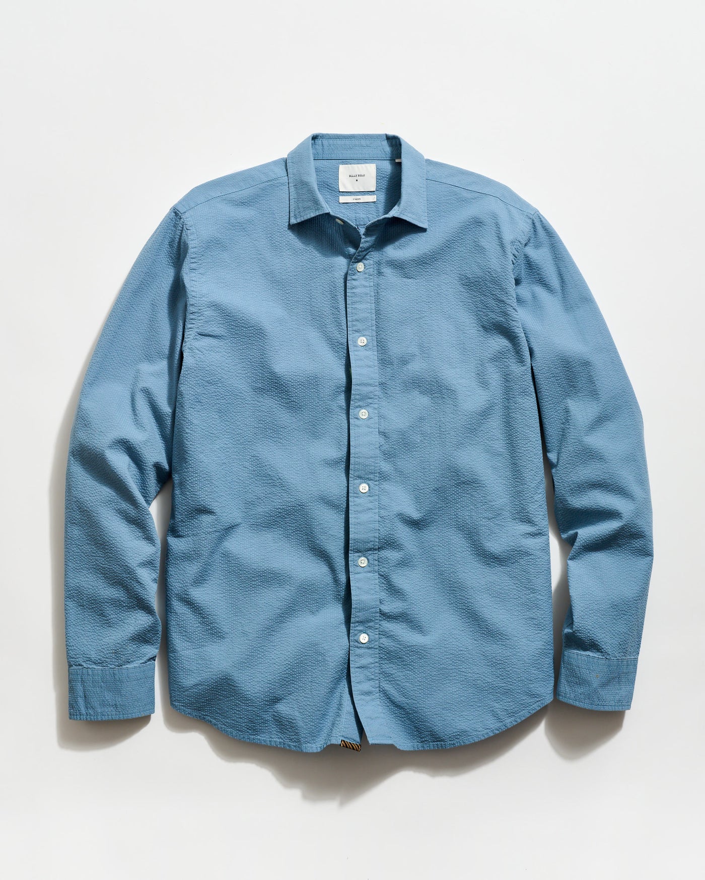 Blue button-up shirt on a light gray background