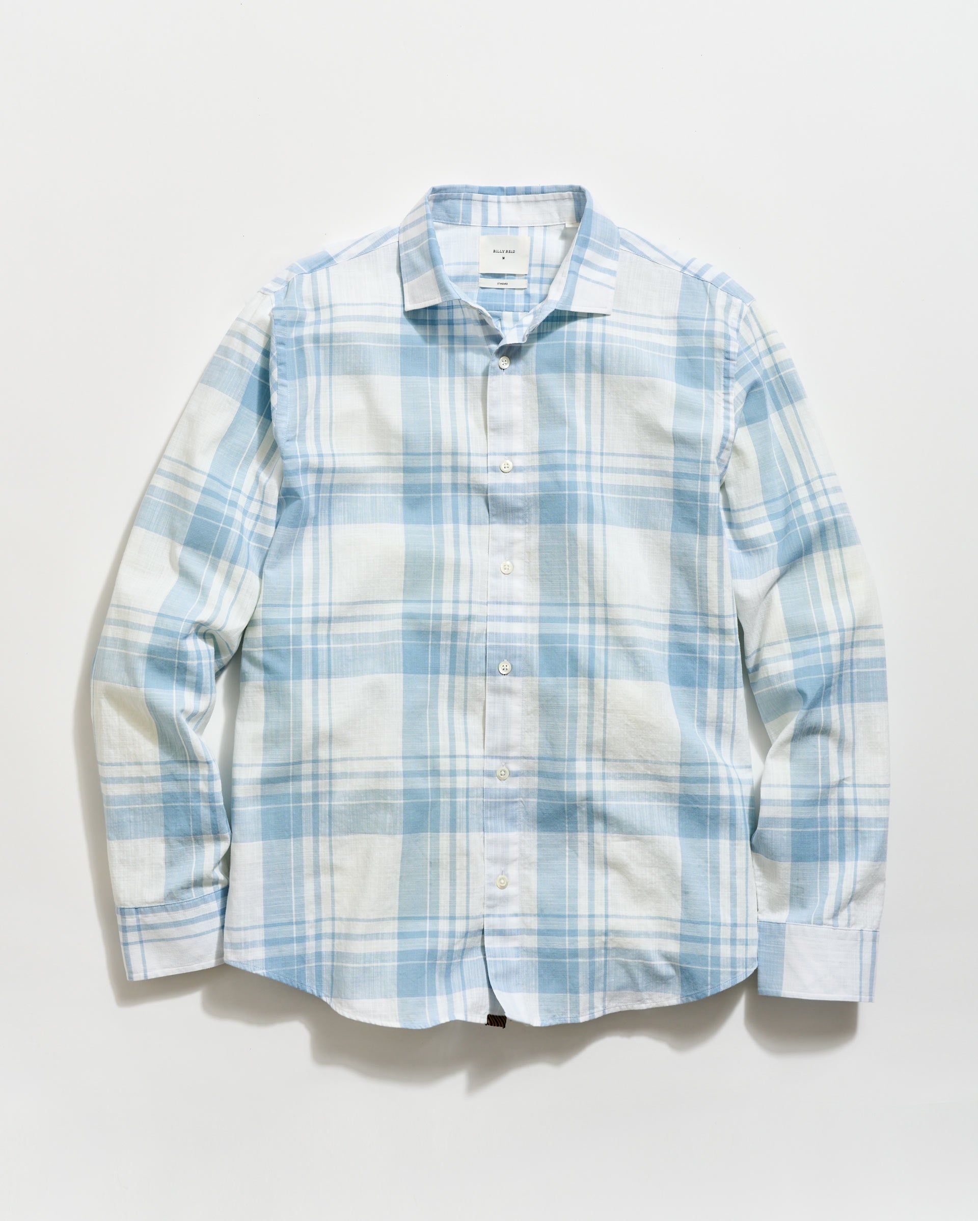 Blue and white plaid shirt on a light gray background