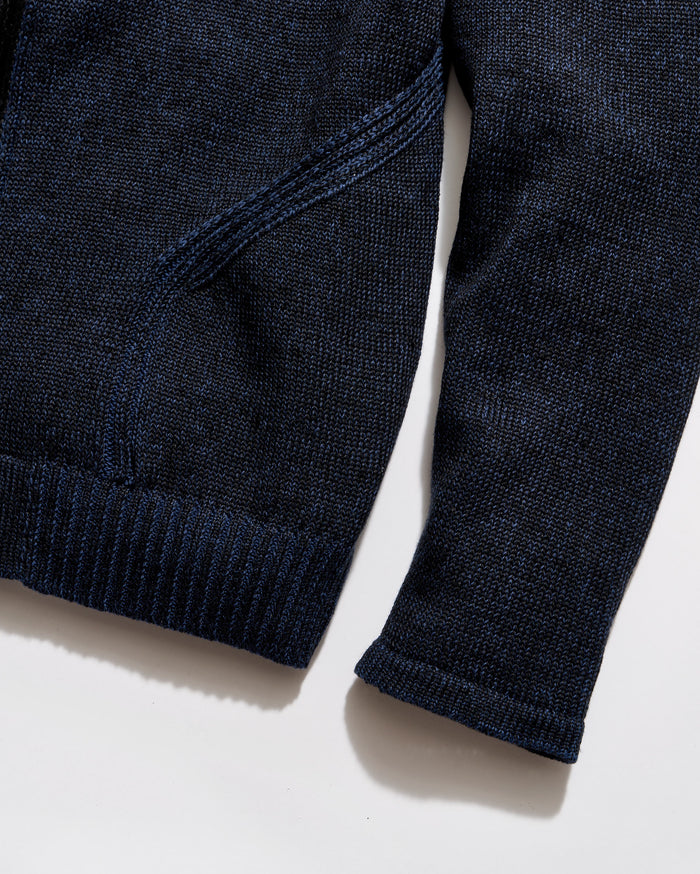 Close-up of a navy blue sweater on a light beige background