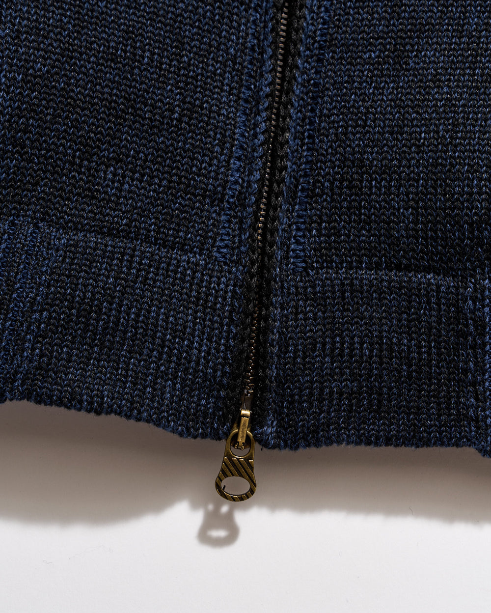 Close-up of a navy blue zipper on a textured fabric background