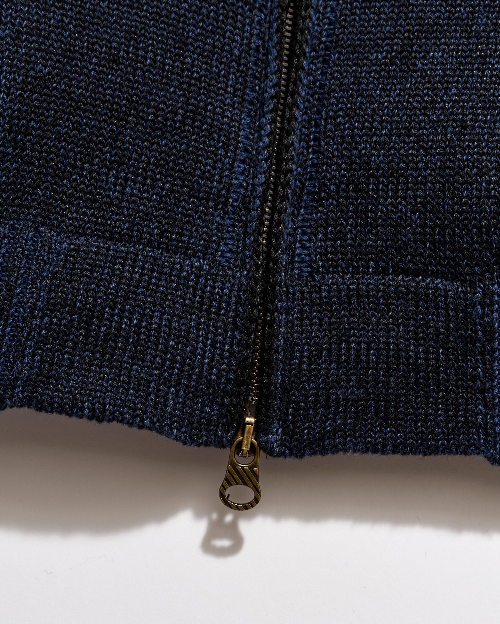 Close-up of a navy blue zipper on a textured fabric background