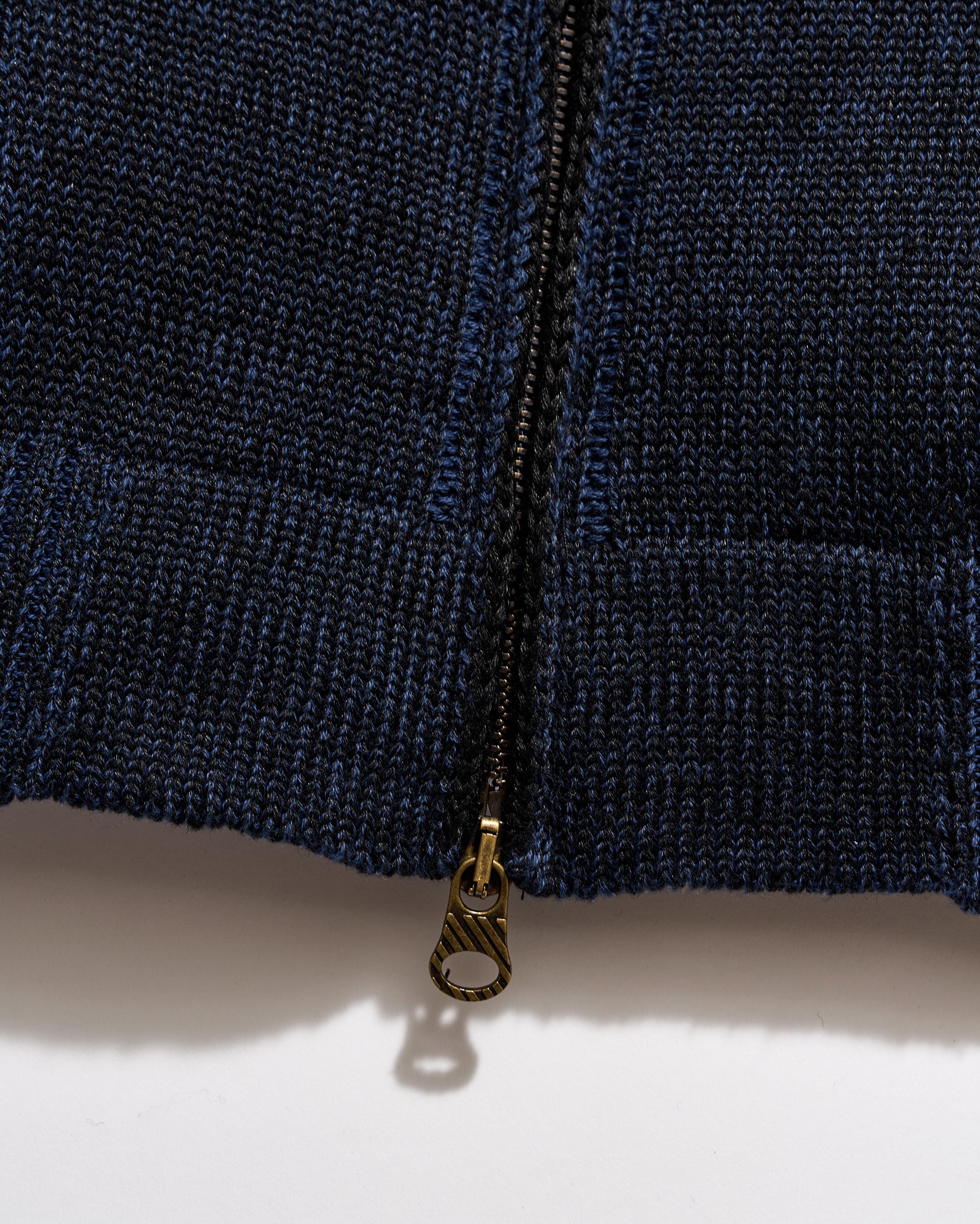 Close-up of a navy blue zipper on a textured fabric background