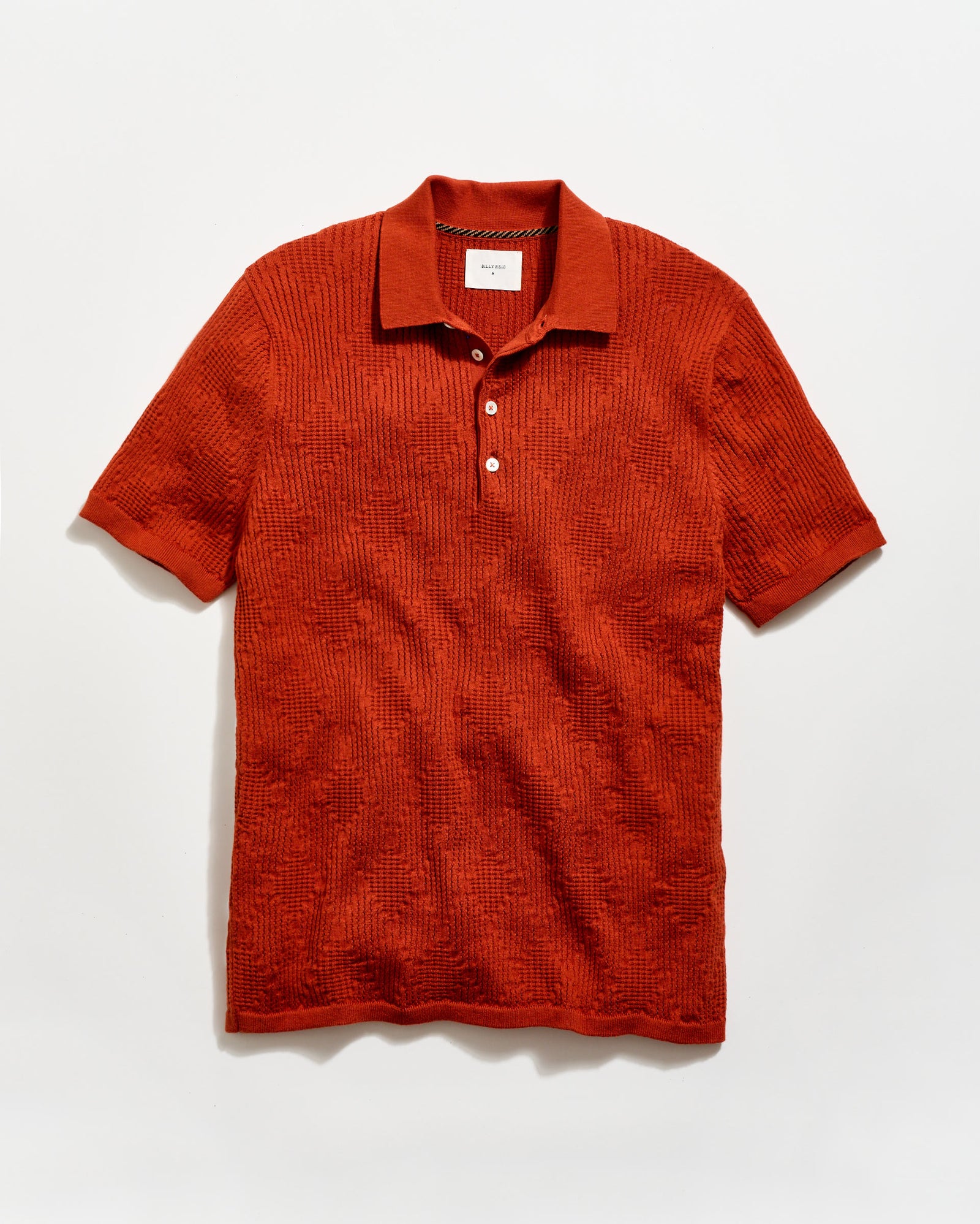 Red textured polo shirt on a light gray background
