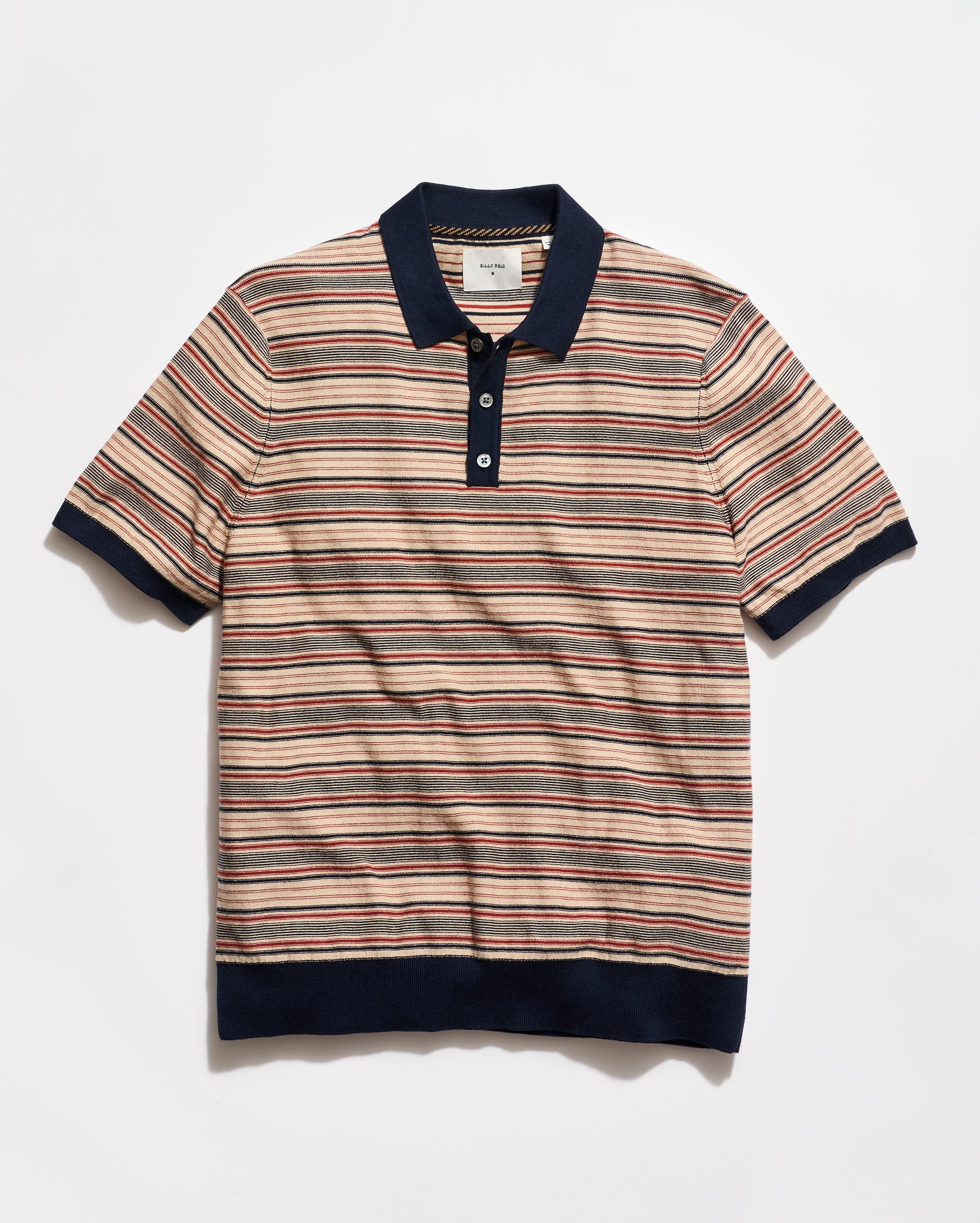 Striped polo shirt with navy accents on a light gray background