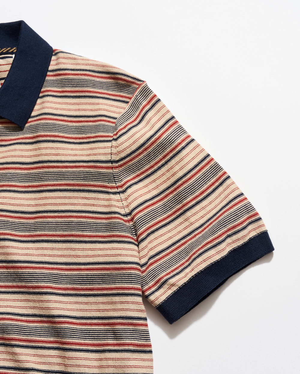 Striped polo shirt with a navy collar on a white background