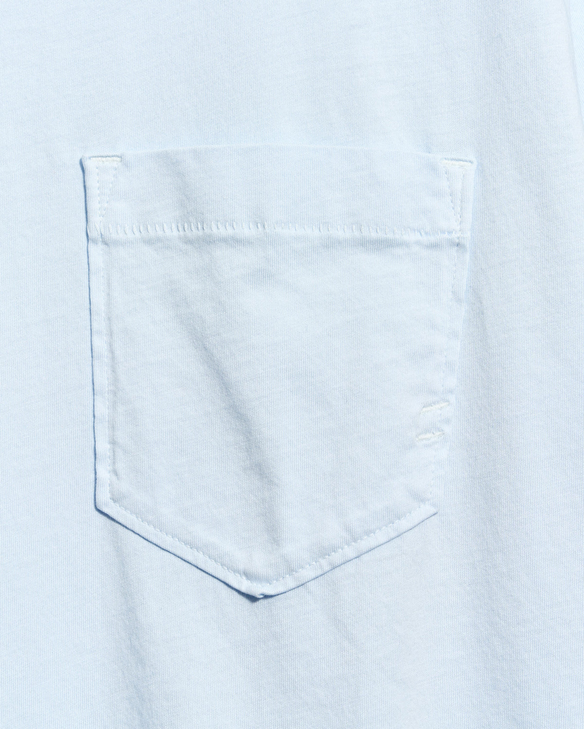 Close-up of a light blue denim pocket on a shirt.