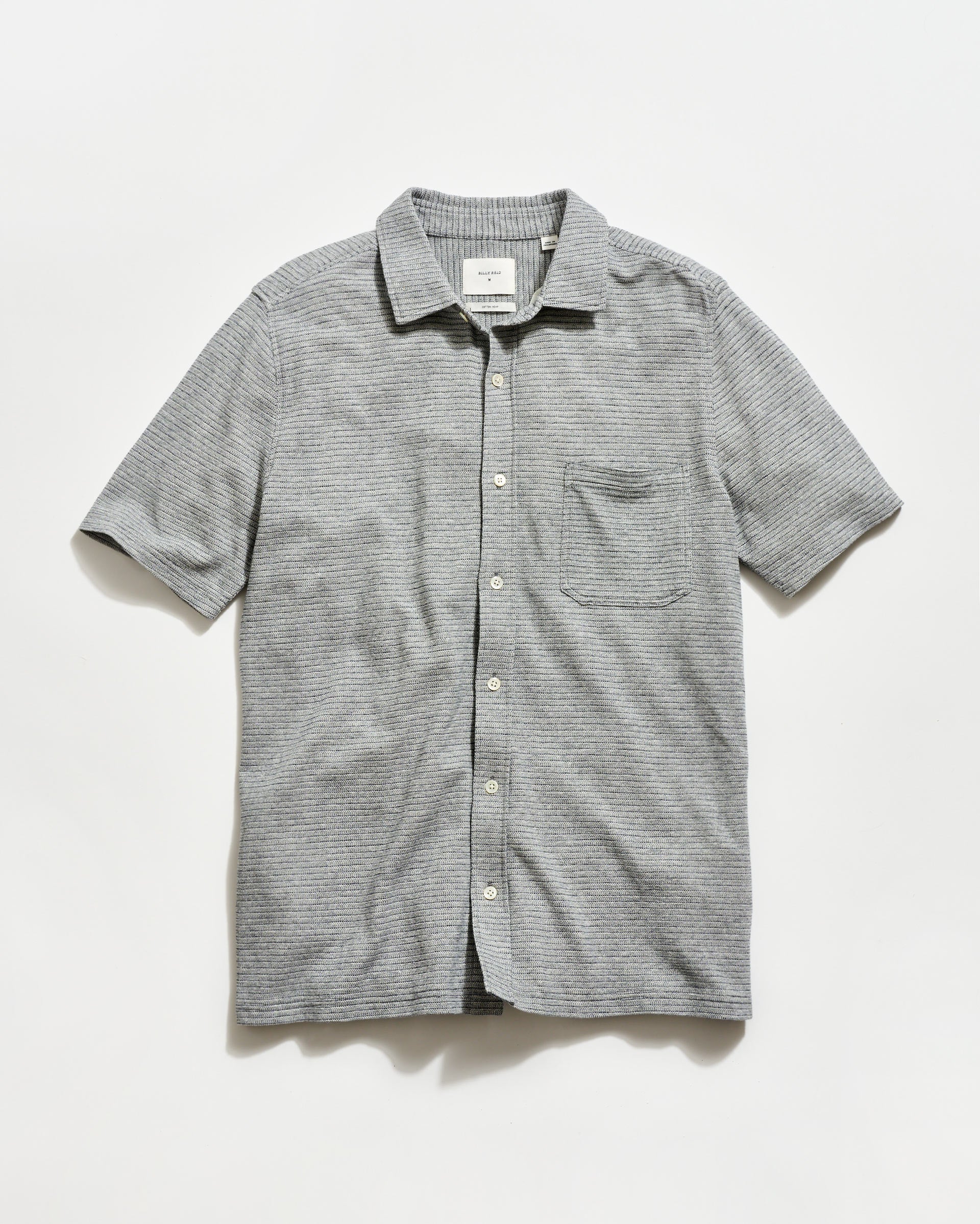 Gray striped short-sleeve shirt on a light gray background
