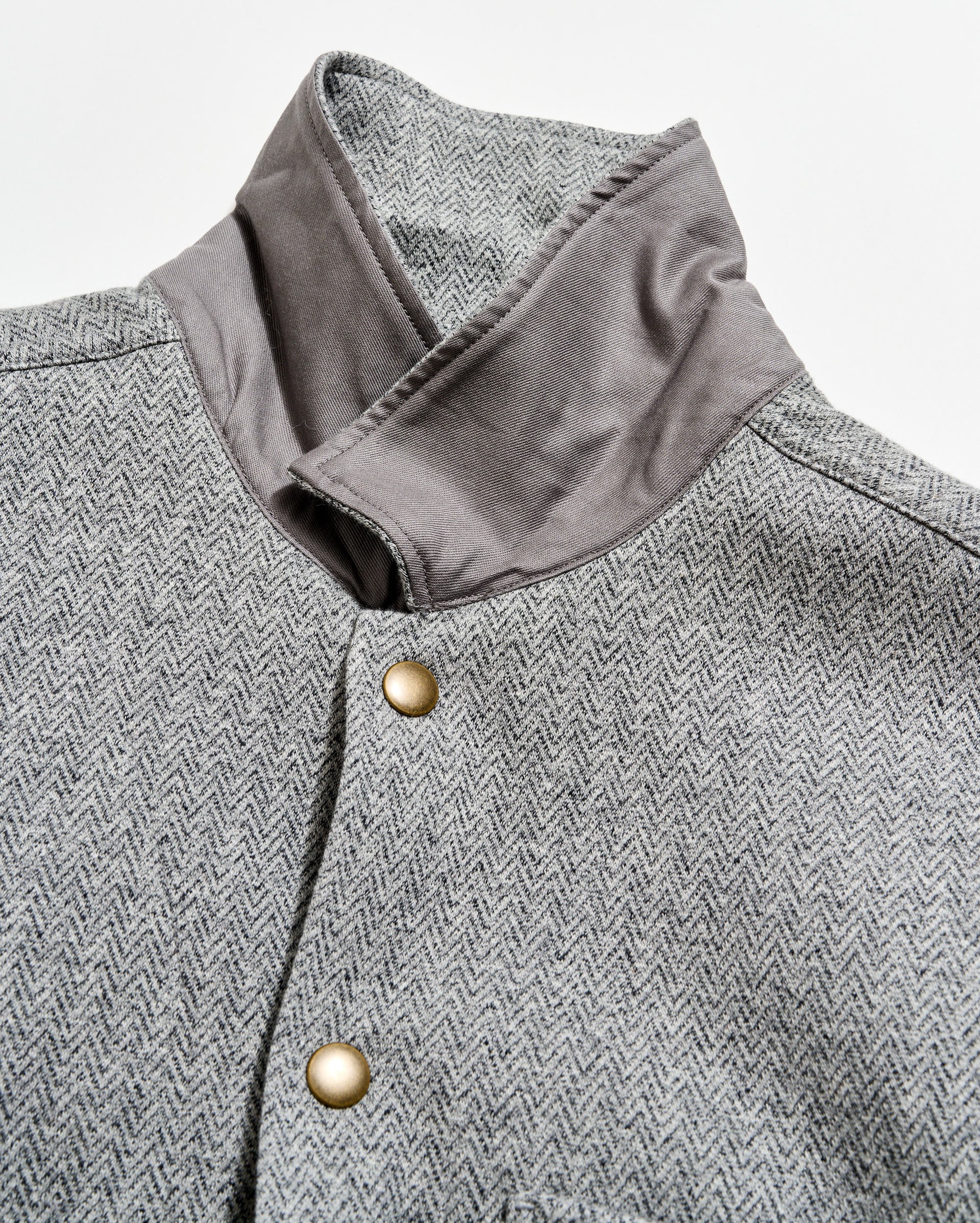 Gray herringbone patterned coat with a close-up of the collar and button details.