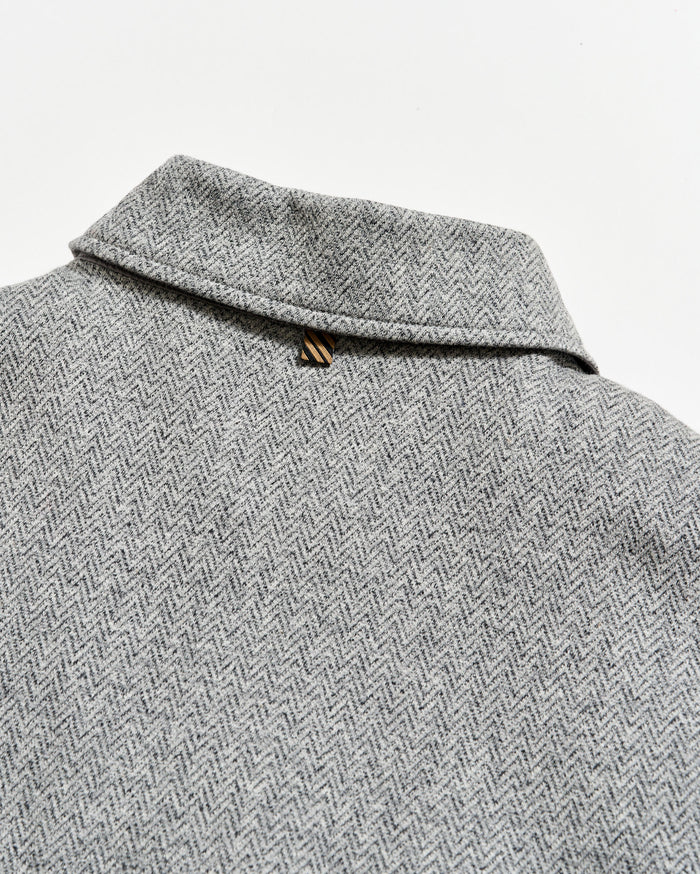 Close-up of a gray herringbone patterned fabric with a collar.