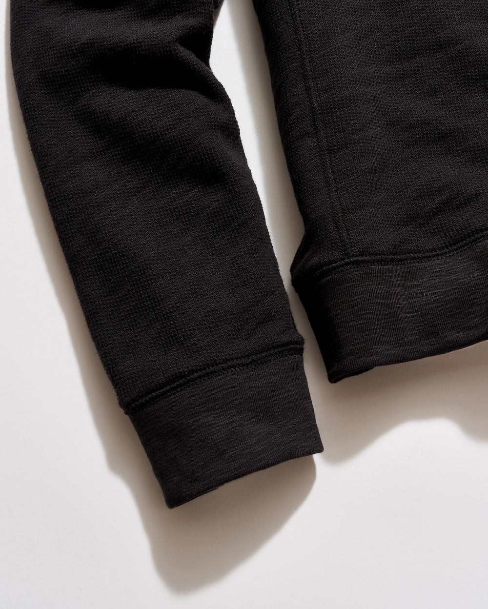 Close-up of black sweatpants on a light background