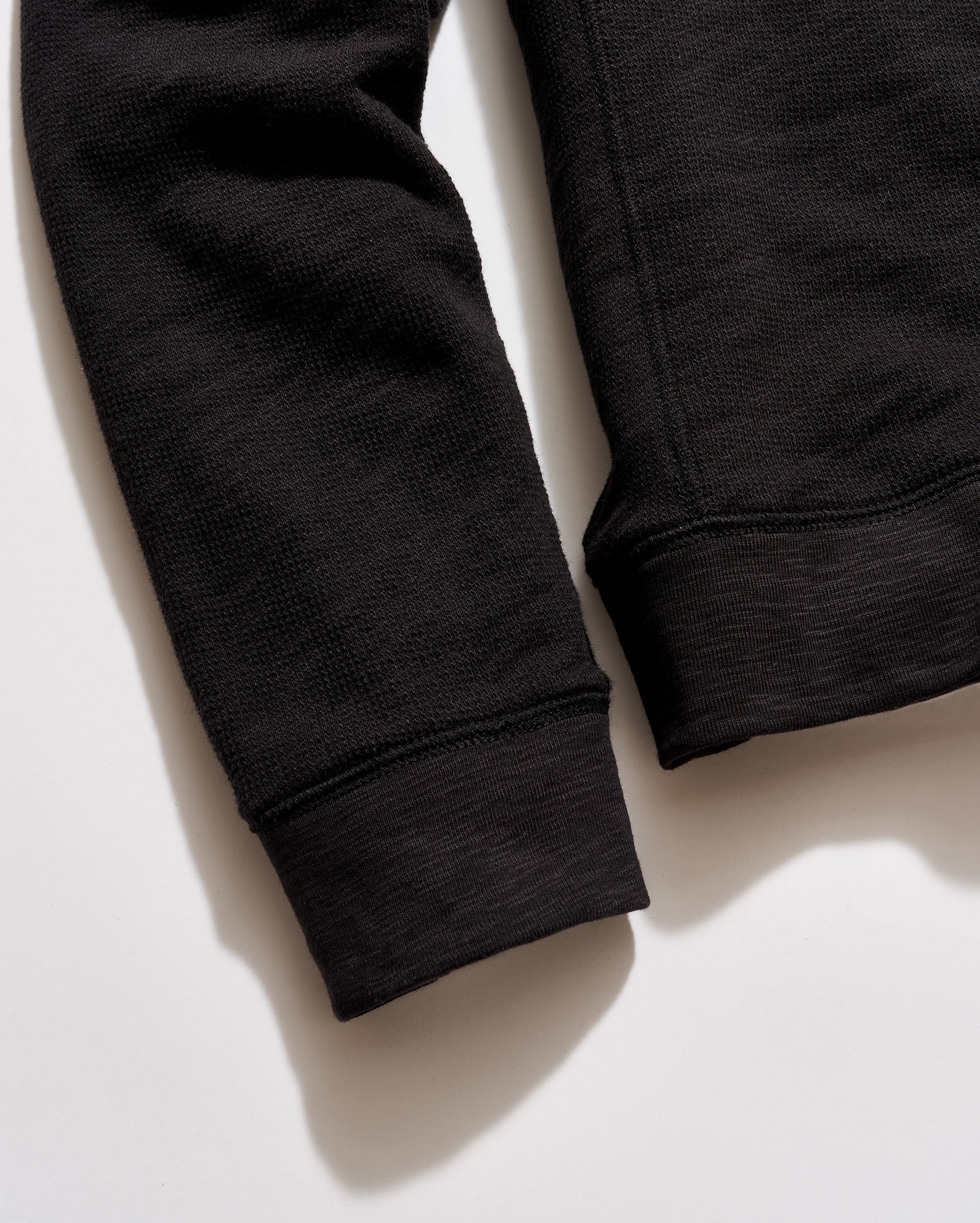Close-up of black sweatpants on a light background