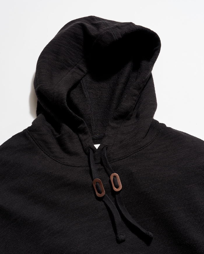 Dark gray hoodie with brown buttons on a white background