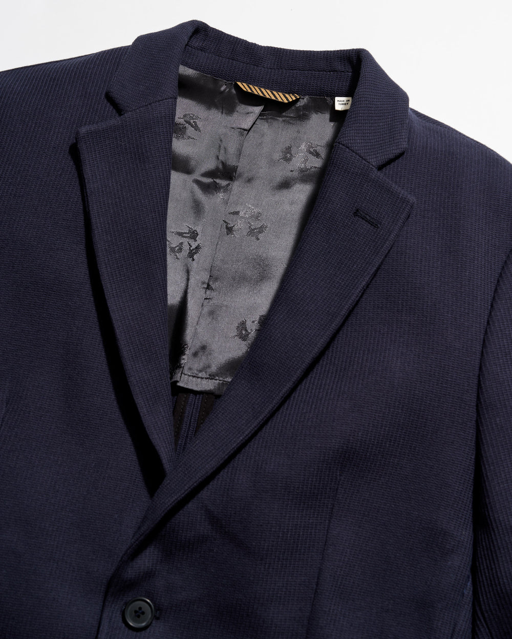 Navy blazer with a floral patterned lining on a white background