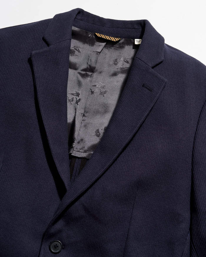 Navy blazer with a floral patterned lining on a white background