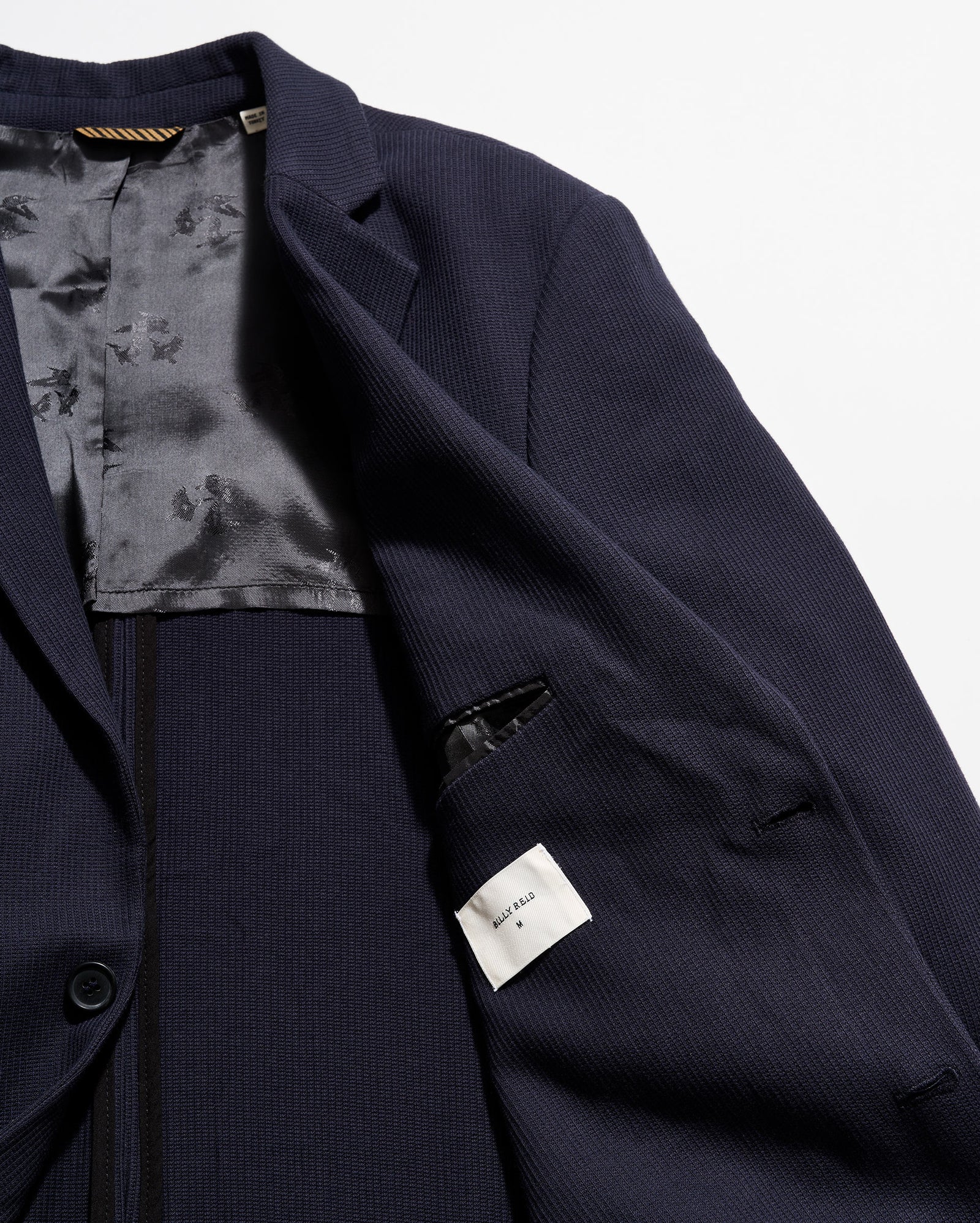 Navy blue suit jacket with floral lining on a white background