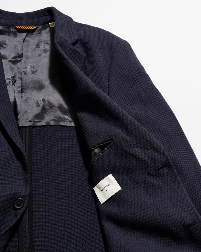 Navy blue suit jacket with floral lining on a white background