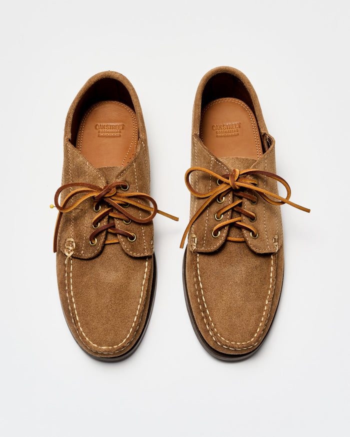 Pair of brown suede shoes with leather laces on a white background