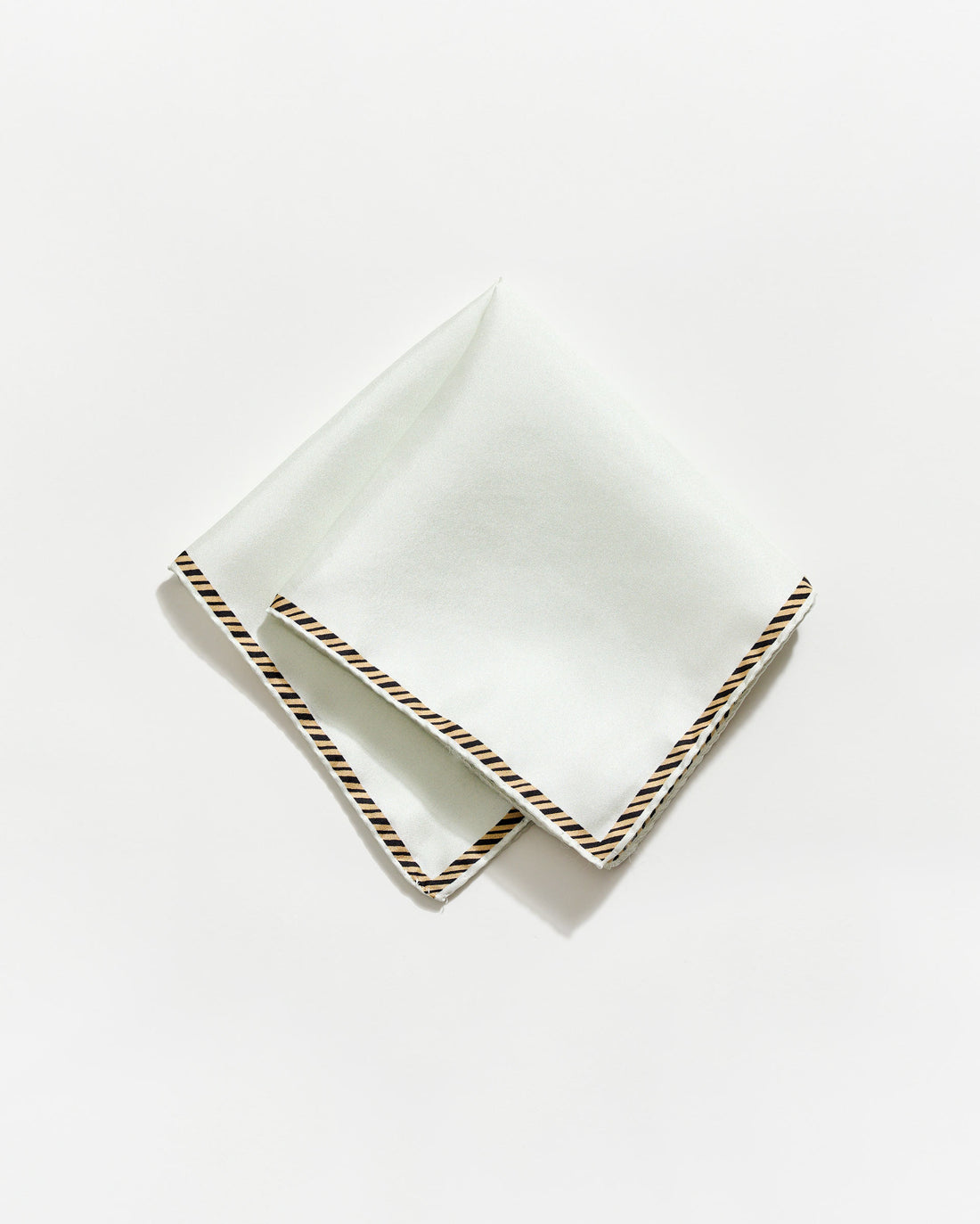 White napkin with gold trim on a white background