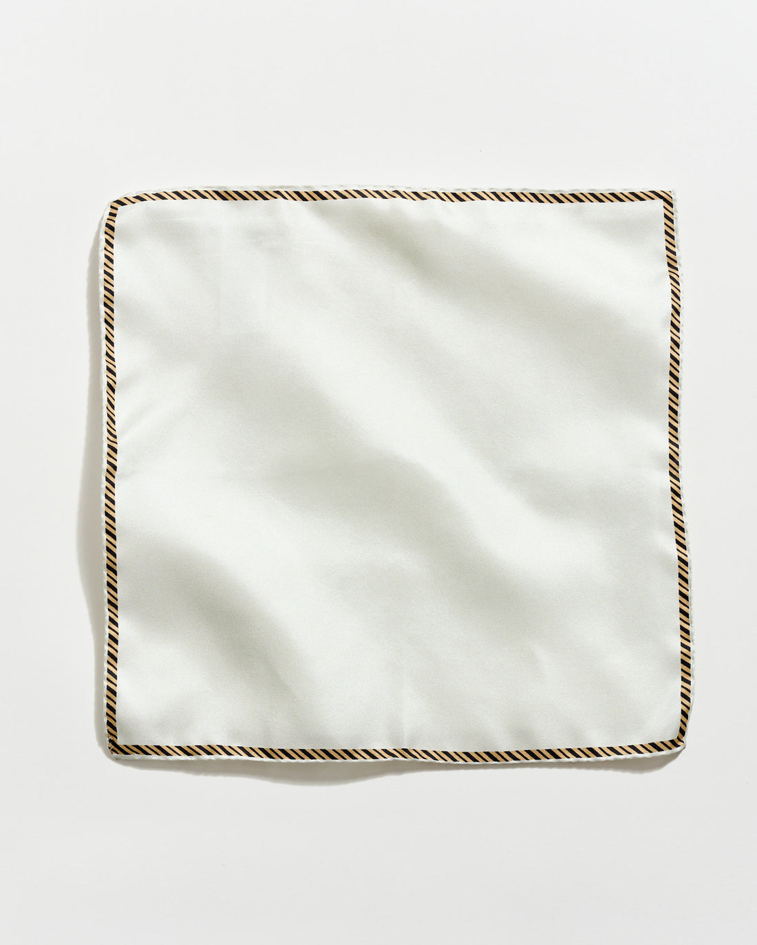White square napkin with decorative brown border on a light gray background