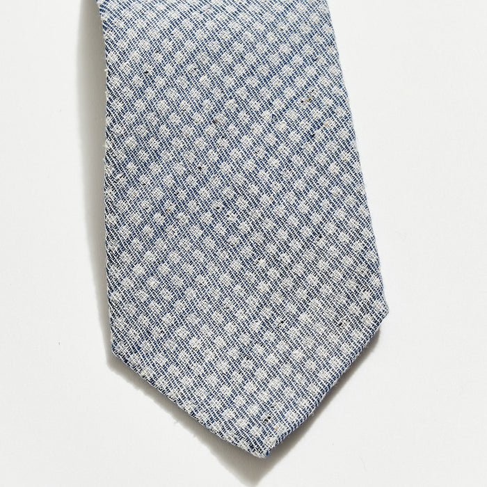 Blue patterned tie on a light gray background