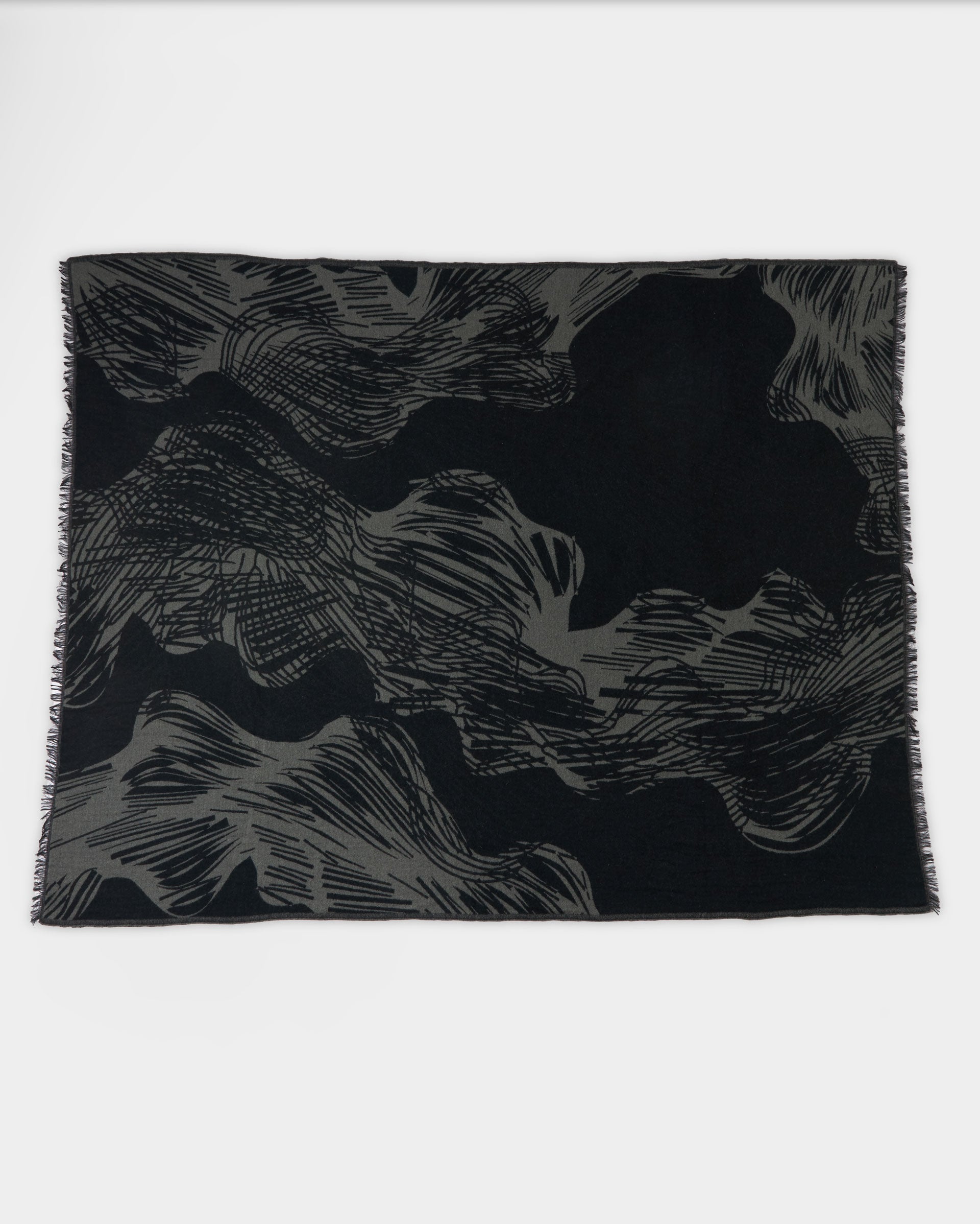 A rectangular black scarf with abstract gray wavy and linear patterns, laid flat on a white background.