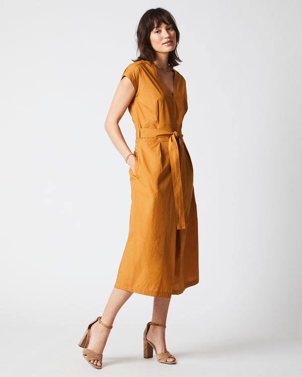 Female model wears the V Neck Dress in Caramel