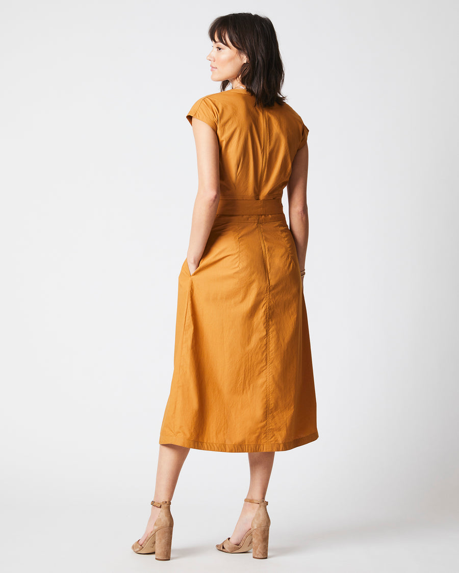 Female model wears the V Neck Dress in Caramel