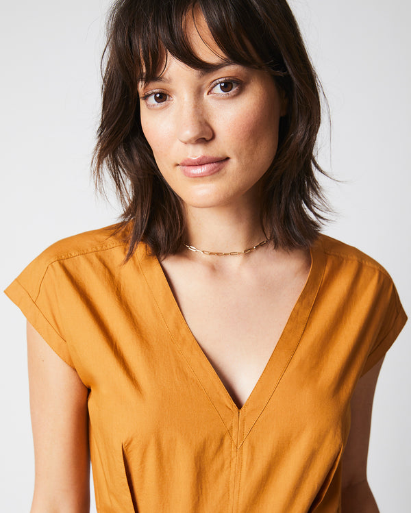 Female model wears the V Neck Dress in Caramel