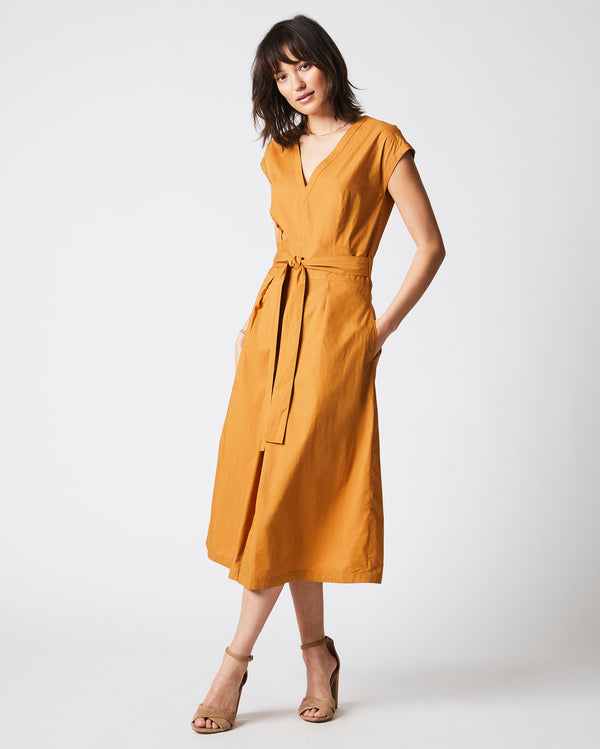 Female model wears the V Neck Dress in Caramel